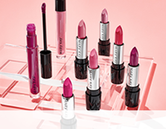 A group of red and pink Mary Kay lipsticks are photographed atop clear plexiglass squares in front of a pink background.