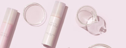 Closed bottle of Mary Kay TimeWise Tone-Correcting Serum styled with clear scientific supplies
