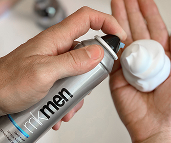 A man dispensing MKMen® Shave Foam into his hand